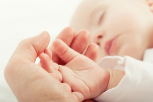 hand the sleeping baby in the hand of mother